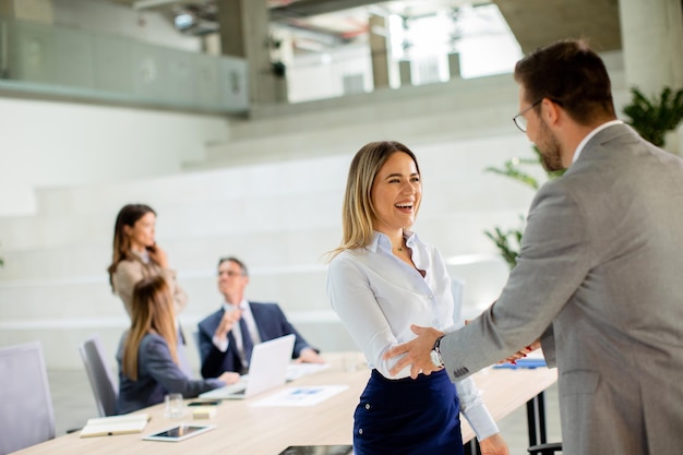 Young business woman handshaking with his colleague in the office