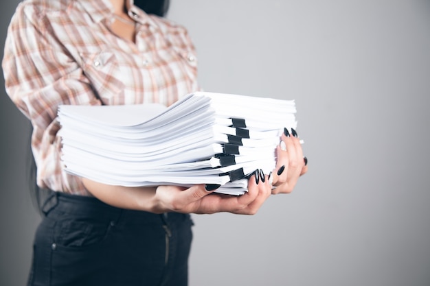 Photo young business woman holding stack of papers
