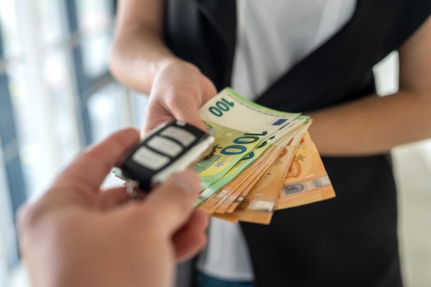 A young business woman is given car keys and she is euros for a car