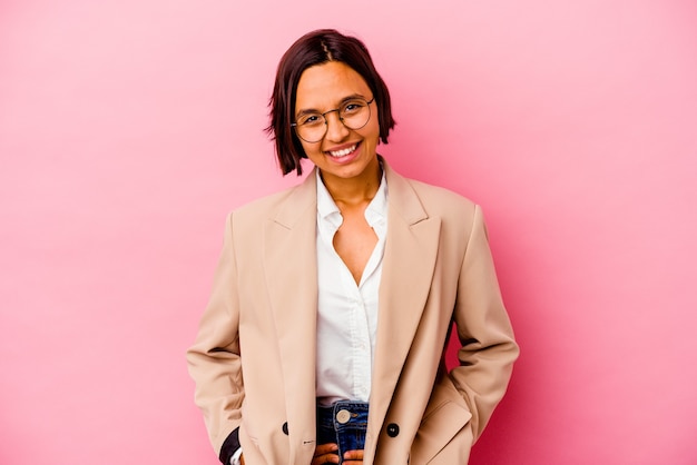 Young business woman isolated on pink wall happy, smiling and cheerful