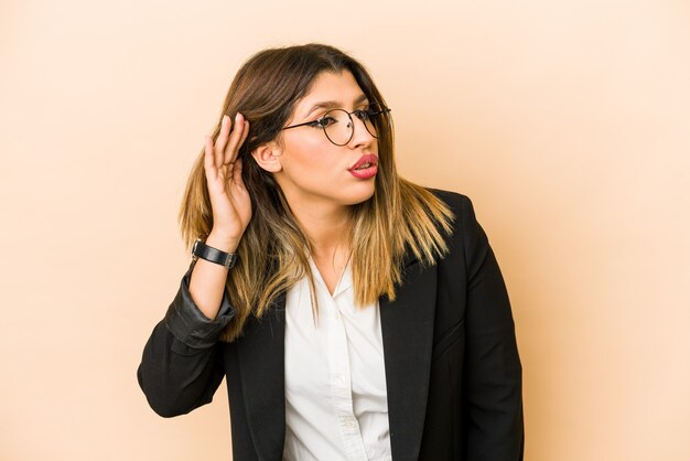 Young business woman isolated trying to listening a gossip