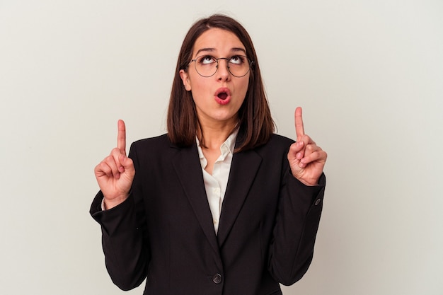 Young business woman isolated on white background pointing upside with opened mouth.