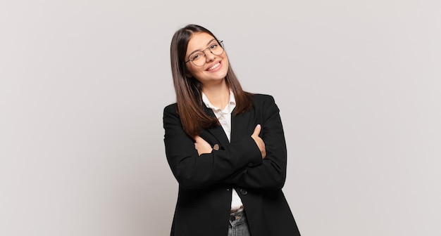 young business woman laughing happily with arms crossed, with a relaxed, positive and satisfied pose