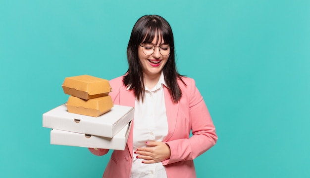 Young business woman laughing out loud at some hilarious joke, feeling happy and cheerful, having fun