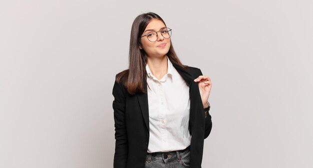 Young business woman looking arrogant, successful, positive and proud, pointing to self