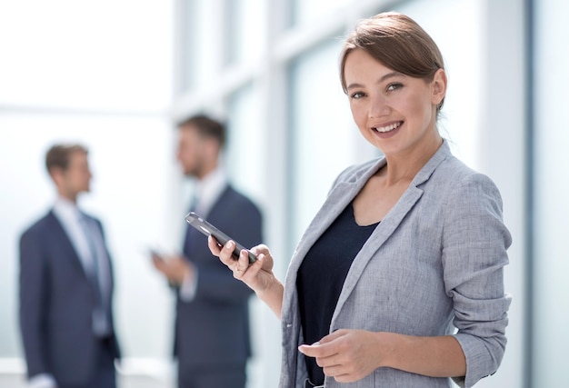 Photo young business woman looking at the screen of her smartphone