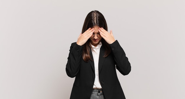 Young business woman looking stressed and frustrated, working under pressure with a headache and troubled with problems