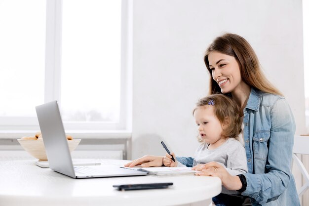 Young business woman in maternity leave using laptop searching in the internet ideas for new projec
