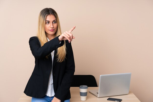 Young business woman in a office touching on transparent screen