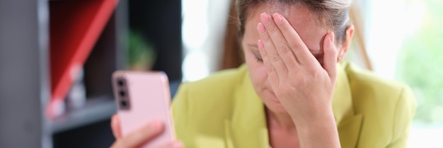 Фото Молодая деловая женщина по телефону смущена получением смс с плохими новостями несчастная женщина