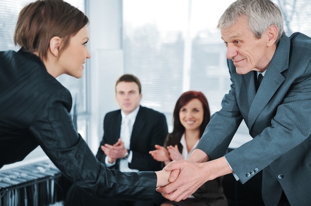 Young business woman passed on a job interview shaking hands with boss