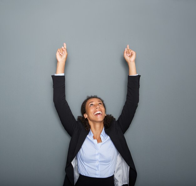 Young business woman pointing fingers up