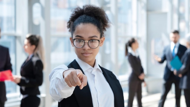 Young business woman pointing at you