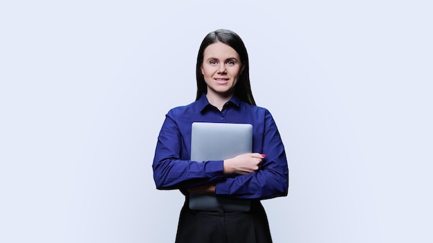 Young business woman posing with laptop on white background