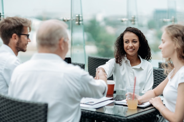 Young business woman shaking hands with her business partner