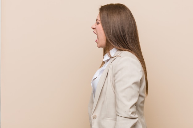 Young business woman shouting towards a copy space