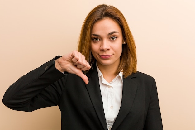 Young business woman showing a dislike gesture, thumbs down. Disagreement concept.