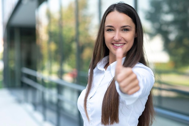Young business woman shows thumb up