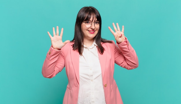 Young business woman smiling and looking friendly, showing number nine or ninth with hand forward, counting down