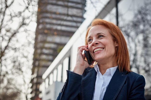 Photo a young business woman talking on mobile phone