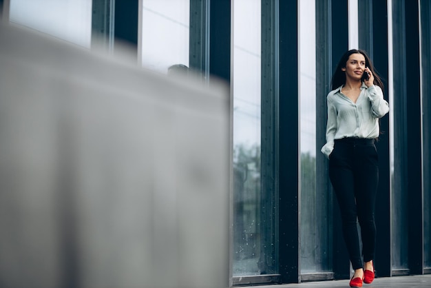 Young business woman talking on the phone by the business center