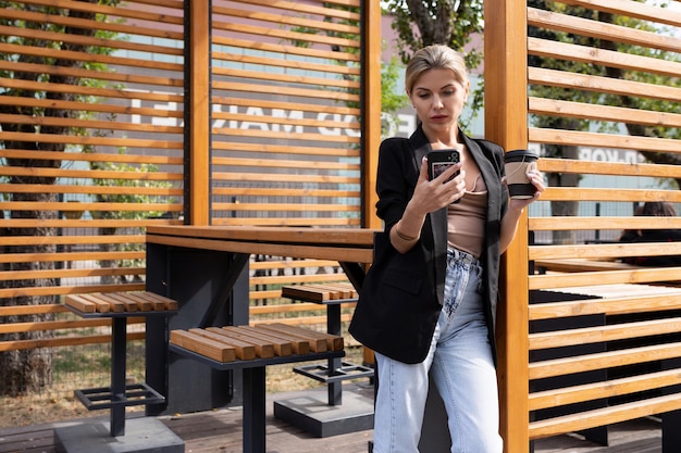 Giovane donna d'affari che parla al telefono all'interno di un caffè di strada