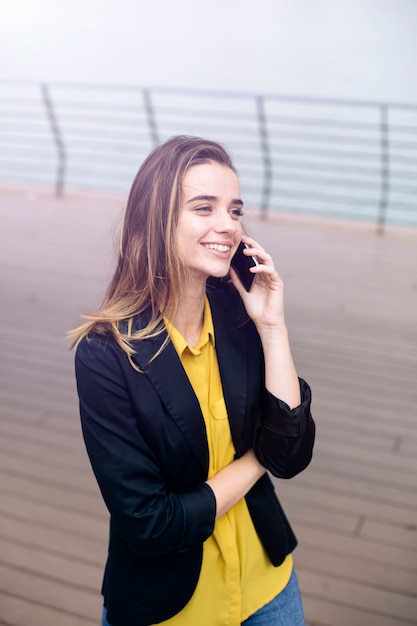 Young business woman uses cellphone at the street