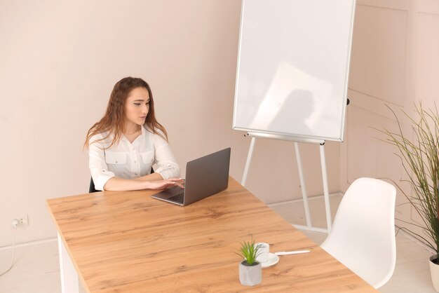 Young business woman using laptop at office