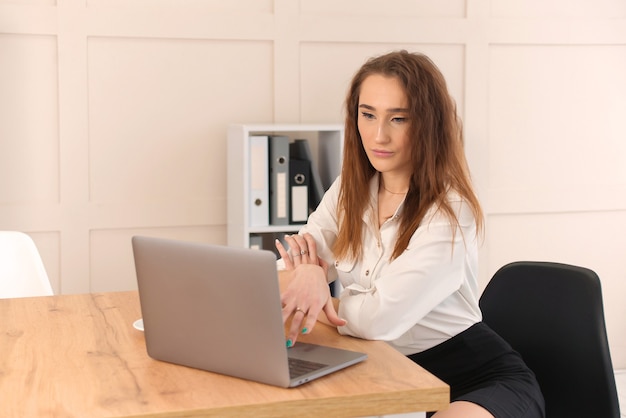 Giovane donna di affari che per mezzo del computer portatile