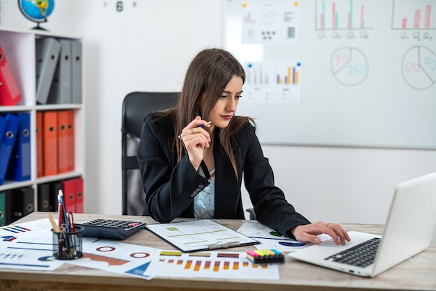 Photo young business woman wear suit work at office analyzing marketing research charts concept of financial report balance