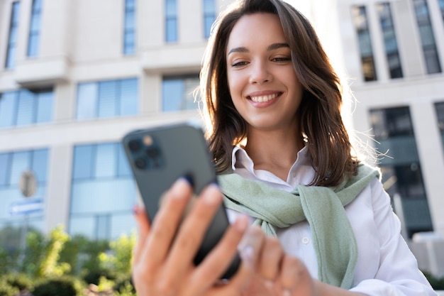 Young business woman wearing professional look smiling confident at the city using smartphone