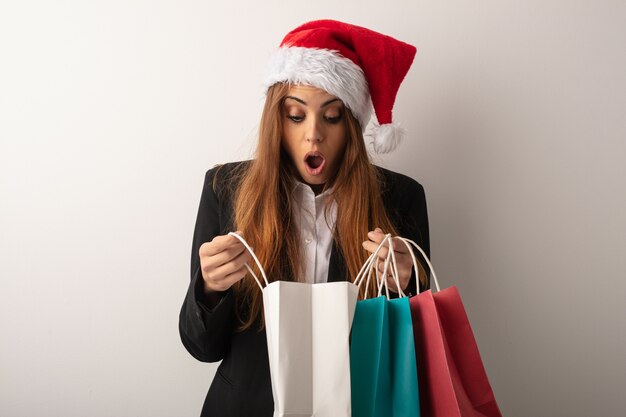 Giovane donna di affari che porta il cappello della santa che celebra giorno di natale