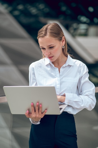 Young business woman in white blouse with a laptop
