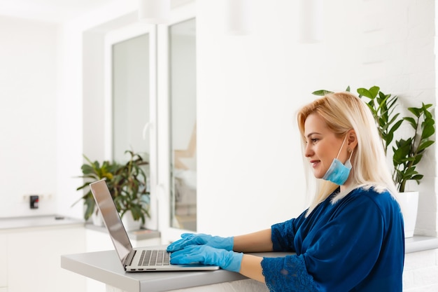 Photo young business woman working from home, wearing protective mask