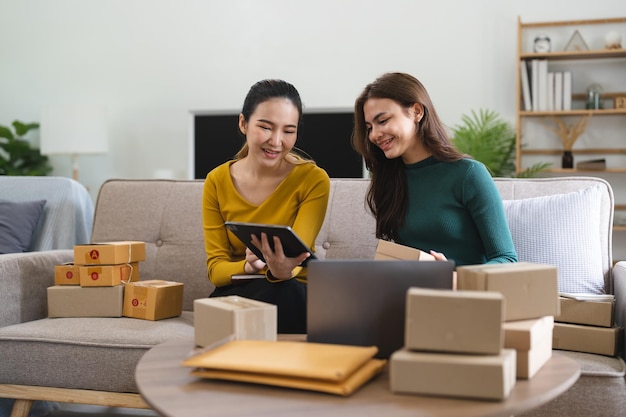 Young business woman working online ecommerce shopping at her
shop young woman seller prepare parcel box of product for deliver
to customer online selling ecommerce