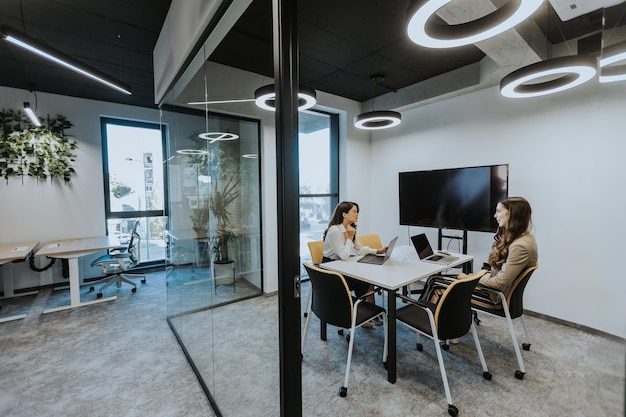 Young business women discussing in cubicle at the modern office