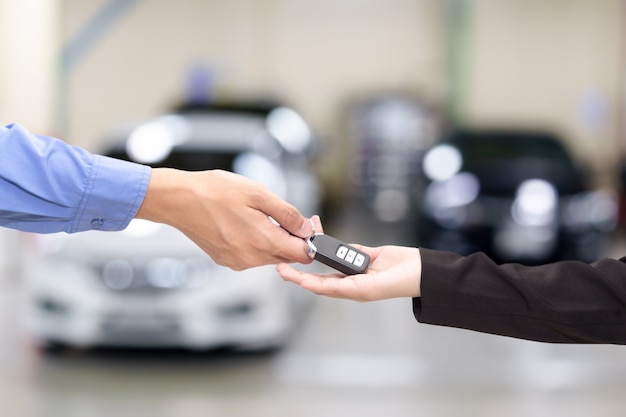 Photo young business women giving a key car in font of car.