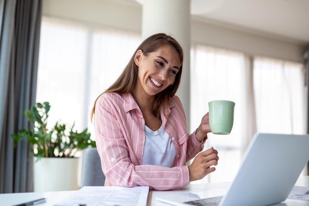 オフィスでコーヒーを飲み窓から眺める若いビジネス女性