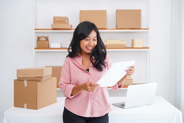 young business women standing in front of table showing her business in cabinet showing confident