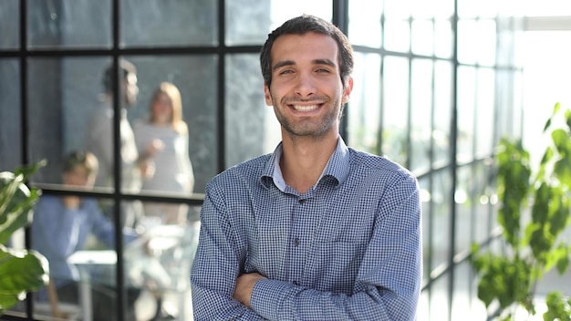 Young businessman in casual clothes stands with his hands on his waist