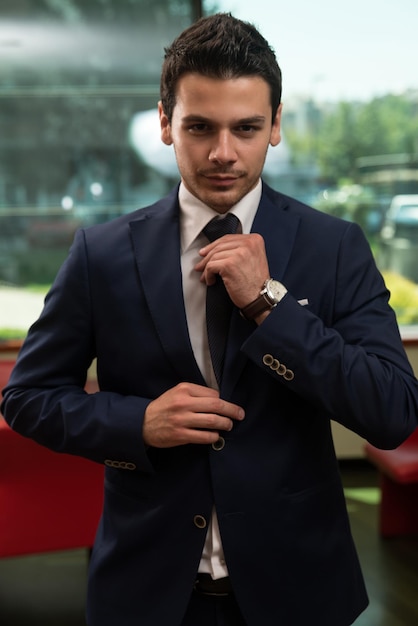 Young Businessman Correcting A Tie