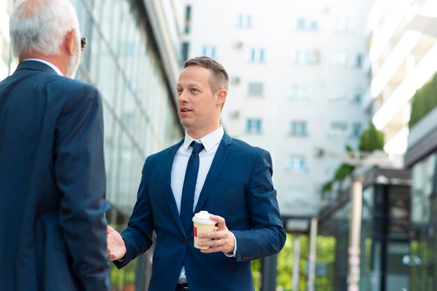 Young businessman discussing something positive with his mature colleague4