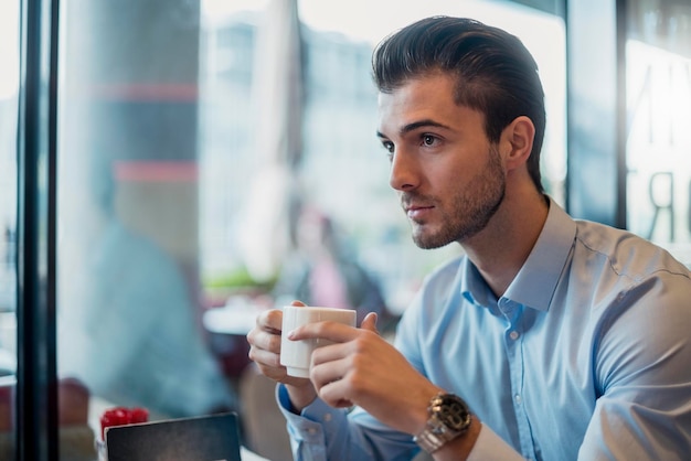 カフェでコーヒーを飲む青年実業家