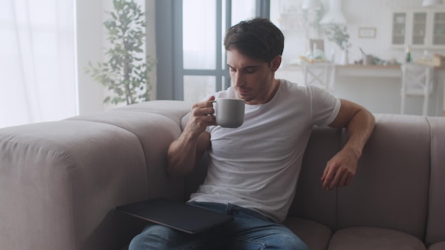 Young businessman drinking coffee at remote workplace in slow motion