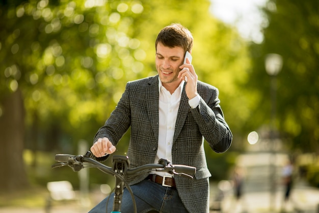 휴대 전화를 사용 하여 ebike에 젊은 사업가