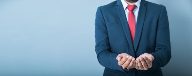 Young businessman empty hand on grey backgroundxA