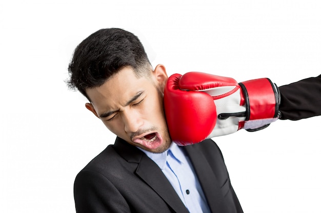 Young businessman getting punch in his face with red boxing gloves. Business competition concept