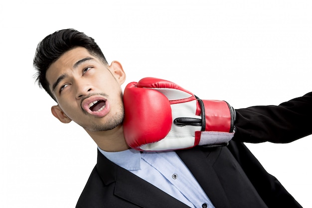 Young businessman getting punch in his face with red boxing gloves. Business competition concept