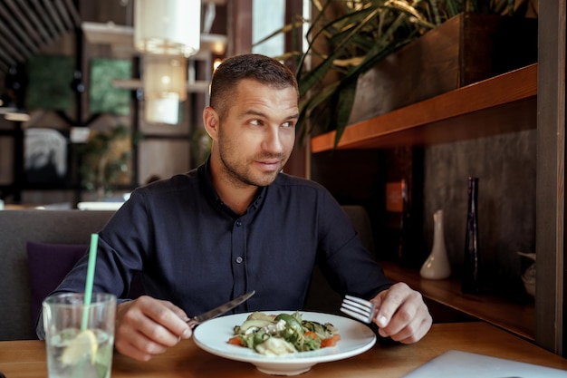 写真 青年実業家はレストランで昼食をとっています