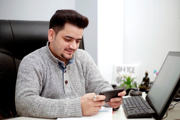 A young businessman is playing game in mobile and enjoying.